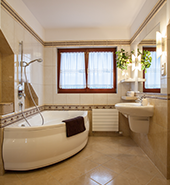 Bathroom with medium size bathtub and shower and a vanity with mirror on the right